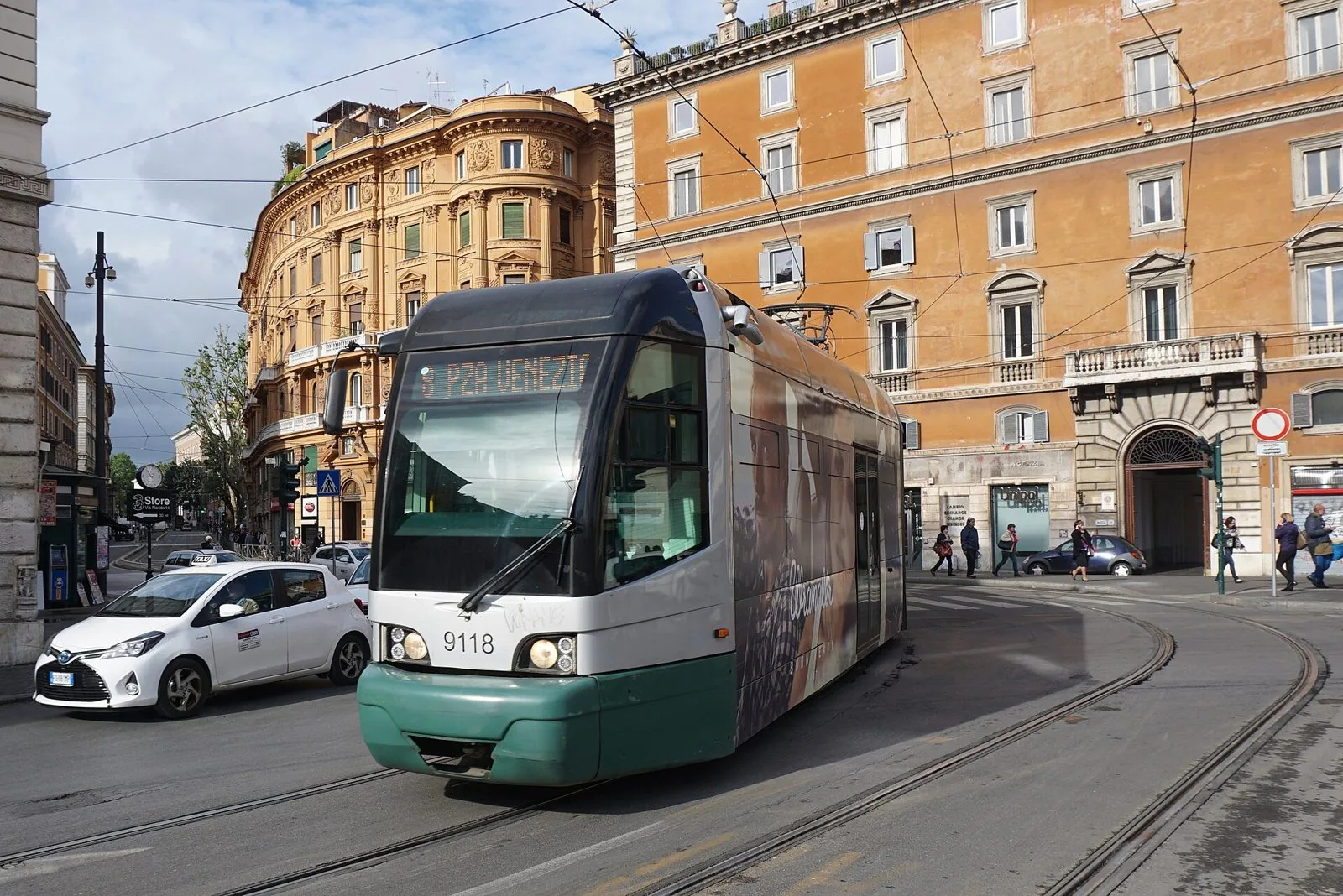 Tram ATAC della linea 8 con destinazione Piazza Venezia che percorre una curva fra palazzi storici del centro di Roma